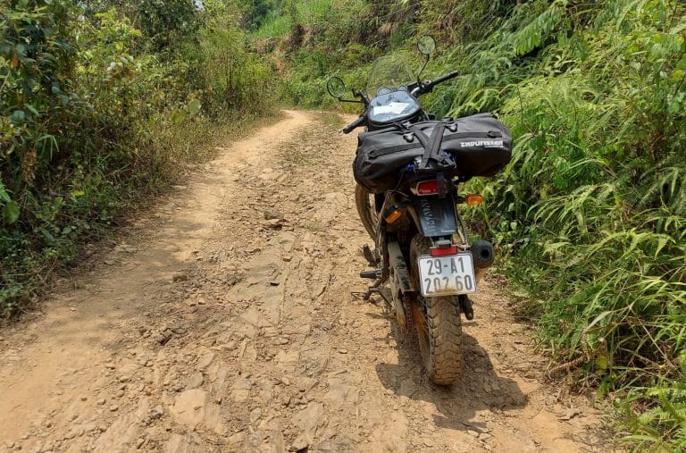 Royal Enfield Himalayan, with Enduristan bag and Roc Straps, parked up on a dirt trail in Ha Giang, Vietnam