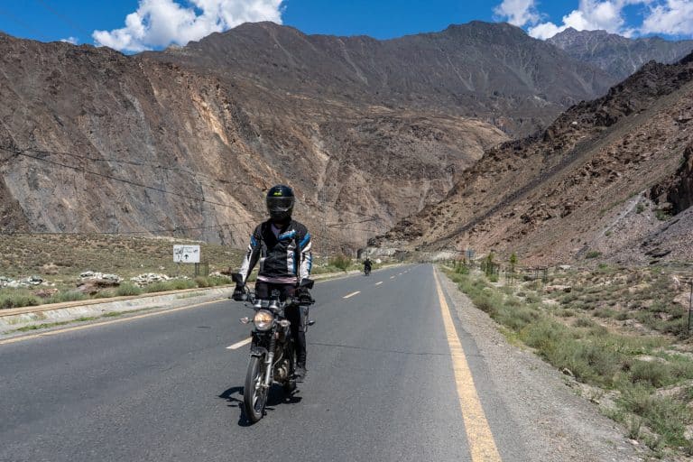 ADV Outrider cruising through a valley while touring the mountains of Pakistan on a motorbike