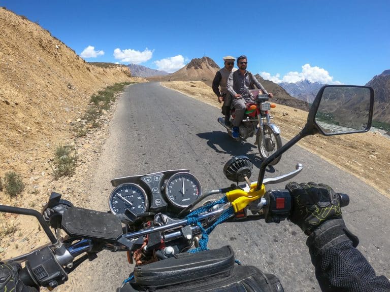 ADV Outrider passes by some locals while on a motorbike tour in Pakistan