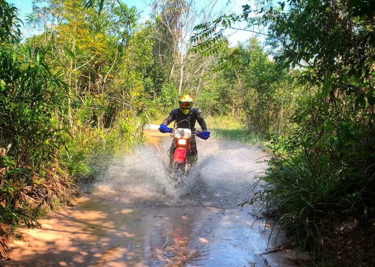 ADV Outrider rides through a river in Cambodian jungle