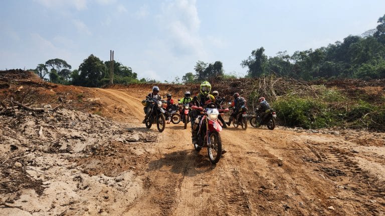 group of ADV Outriders stop on dirt road in Cambodia