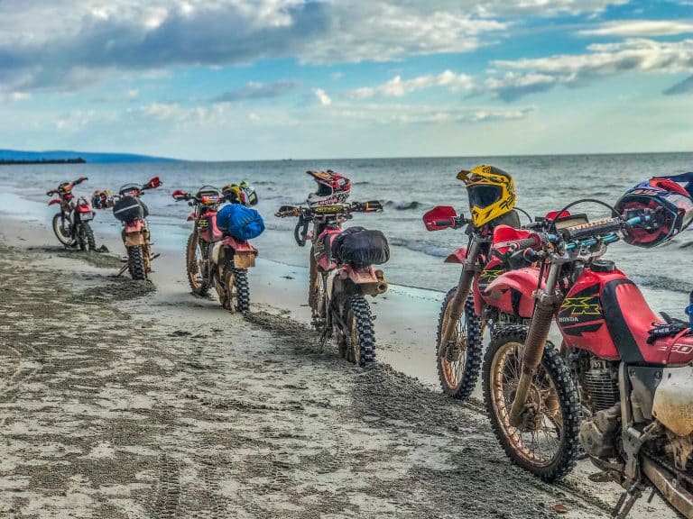 motorbikes parked next to the shoreline on scenic motorbike tour in Cambodia