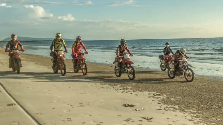 team of ADV Outriders cruise along beach at Bokor National Park