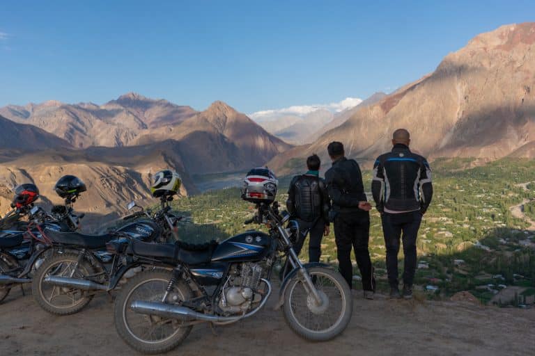 three ADV Outriders look out over the mountains of Pakistan while on a motorbike tour