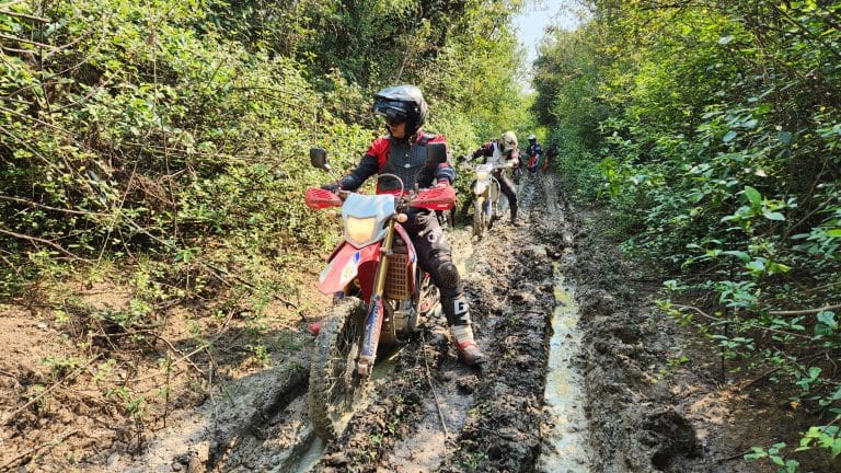 three ADV Outriders ride on muddy trail in Cambodia